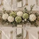 Decoration table mariage avec nappe ivoire, hortensias et marque-places